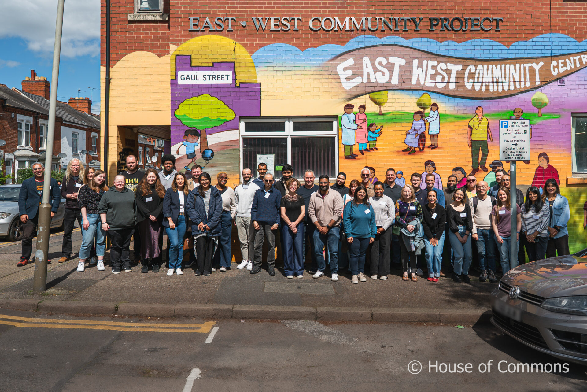 Group of people stanging in front of a brightly coloured building. The people include participants of the deliberative workshops organised by the Home Affairs select committee of the UK House of Commons, and staff involved delivering the workshops